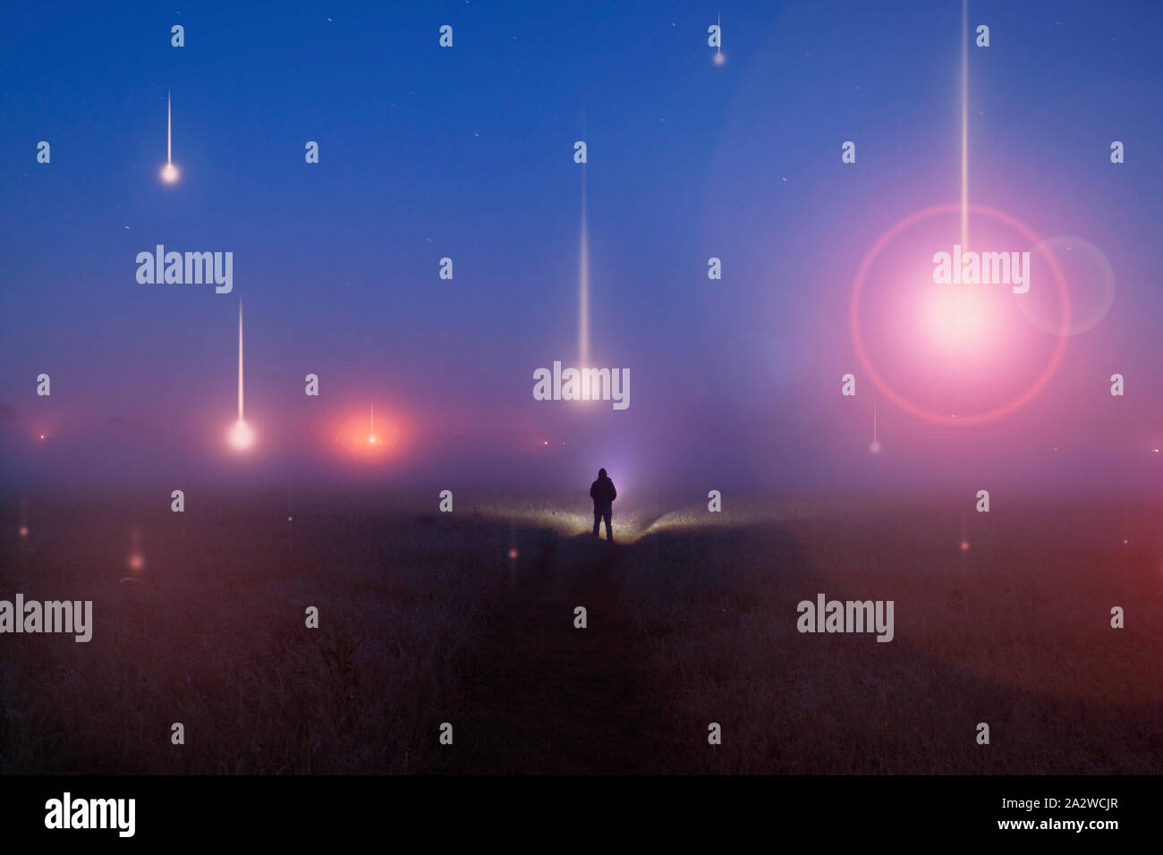 UFO-Konzept. Leuchtende Kugeln, schweben über einem nebligen Bereich in der Nacht. Mit einem silhoutted Abbildung auf der Suche an der Ampel. Stockfoto