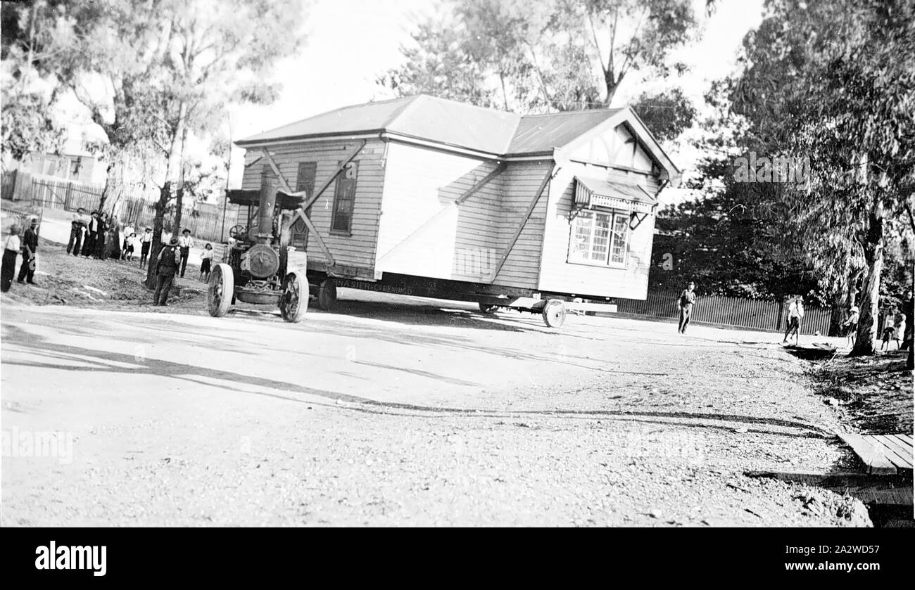 Negative - Bendigo, Victoria, ca. 1925, eine Lokomobile verwendet wird, um ein Haus zu bewegen. Das Haus ist von diagonalstreben verspannt. Das Haus und der Motor Drehen einer Straße Ecke Stockfoto
