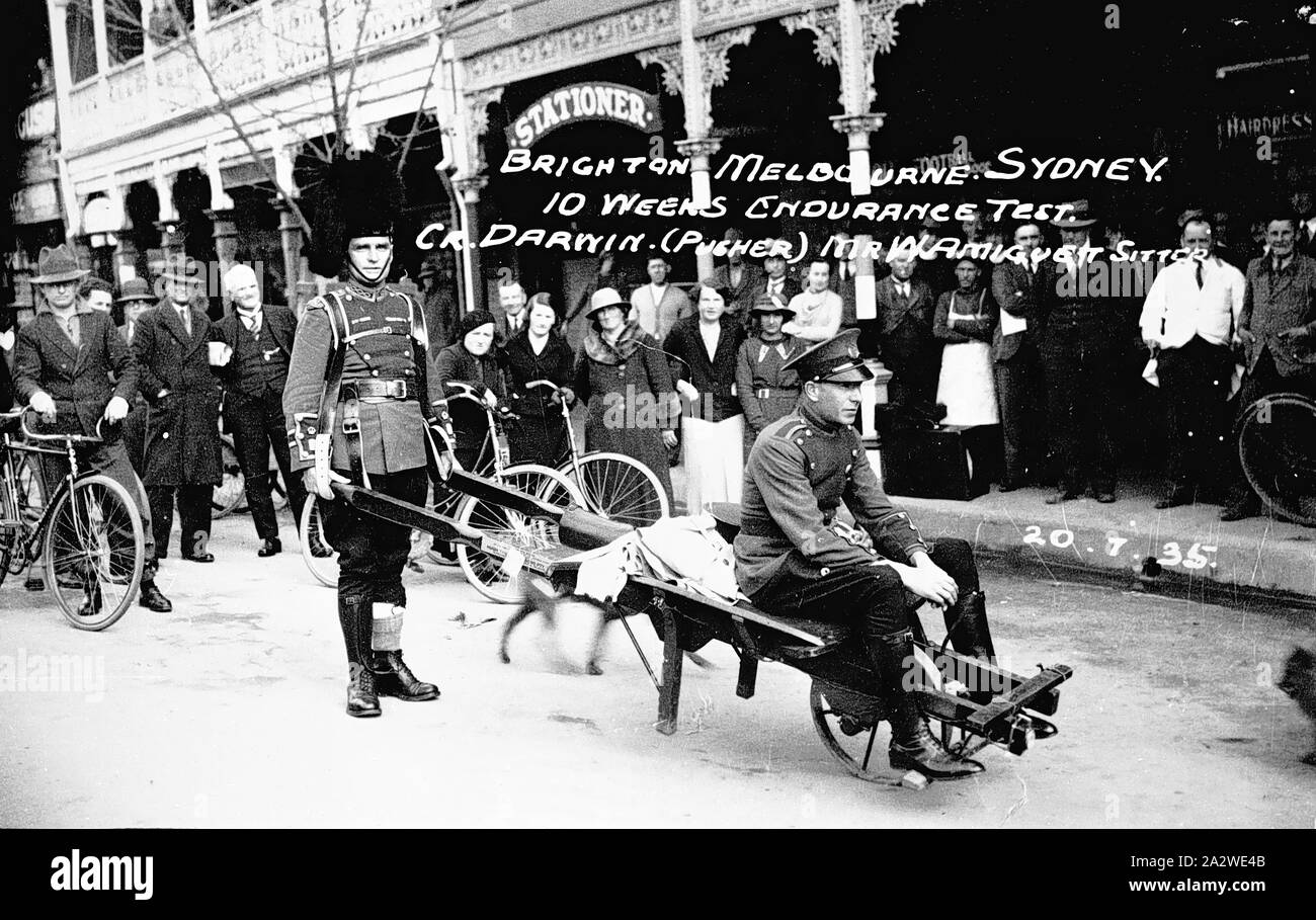 Negative - Wangaratta, Victoria, 1935, ein Mann in Uniform ein weiteres Drücken auf einer schubkarre als Teil einer Dauertest von Melbourne nach Sydney. Die Uniformen nicht angezeigt werden regelmäßige Service Uniformen zu sein. Den Kopf des Stieres und Albion Hotels sind im Hintergrund Stockfoto