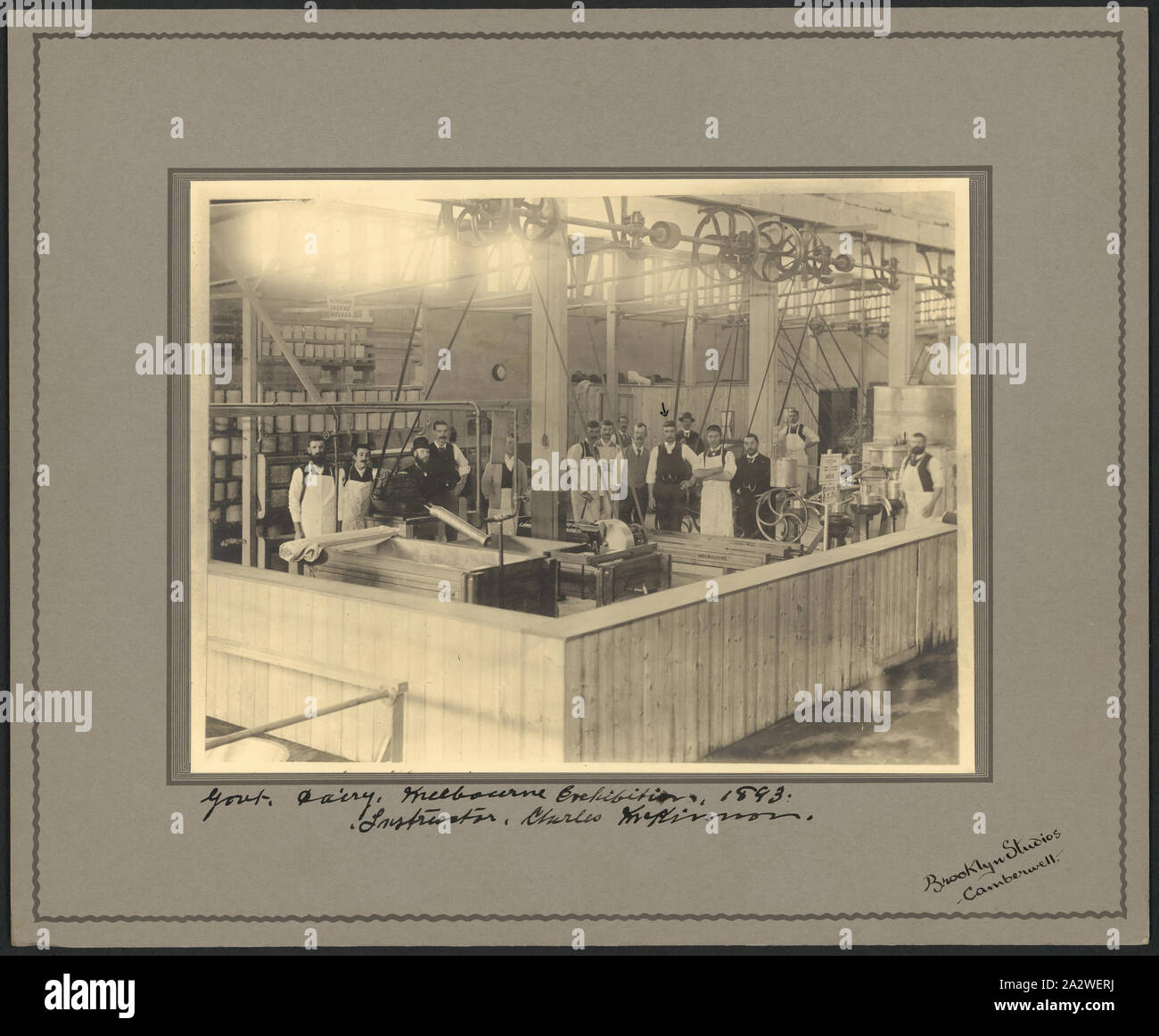 Digitale Fotografie - Molkerei & Arbeiter, Ausstellungsgebäude Anhang, 1888, Digital Scan für ein Foto von der Käserei und der Arbeitnehmer an der Regierung von Victoria Molkerei am Melbourne Centennial International Exhibition. Das Foto zeigt die 15 Männer, viele tragen weiße Schürze, die von Betriebseinrichtungen umgeben. Der Mann mit einem Pfeil markiert wird behauptet Charles McKinnon, der die Regierung von Victoria Molkerei "Käserei" war. Der Käse Werk installiert Stockfoto