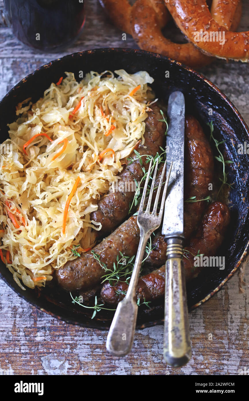 Oktoberfest essen. Bayerische Wurst und Sauerkraut in der Pfanne. Bayerisches Bier frisch essen. Oktoberfest. Selektive konzentrieren. Makro. Stockfoto