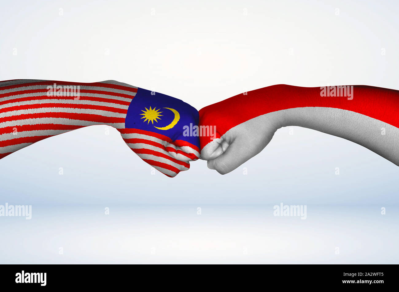 Fist bump der malaysische und indonesische Fahnen. Zwei Hände mit gemalten Flaggen von Malaysia und Indonesien Flagge Faust stoßen als Symbol der Einheit. Stockfoto