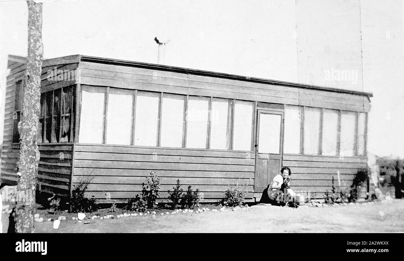 Negative - Red Cliffs, Victoria, ca. 1930, das dritte Haus auf der Siedler. Eine Frau sitzt an der Haustür. Sie hält einen Hund Stockfoto