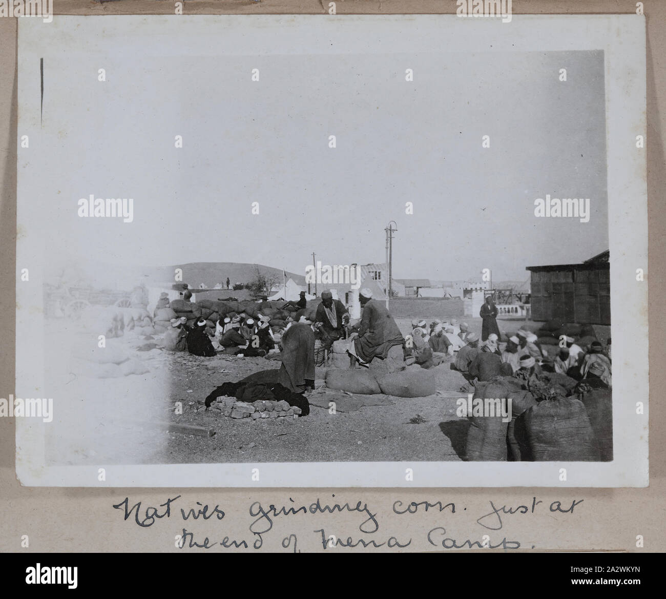 Foto - "Eingeborenen Schleifen Mais im Mena Camp', Ägypten, Kapitän Edward Albert McKenna, der Erste Weltkrieg, 1914-1915, einer der 139 Fotos in ein Album vom Ersten Weltkrieg wahrscheinlich durch Kapitän Edward Albert McKenna genommen worden zu sein. Die Fotografien gehören die 7 Bataillon Ausbildung in Mena-Camp, Ägypten, und sight-seeing. Bild zeigt eine Gruppe von Ägypter schleifen Mais an Mena-Camp. Mena-Camp war einer von drei Trainingslager in Ägypten durch die A.I.F. und die N.Z.E.F verwendet Stockfoto