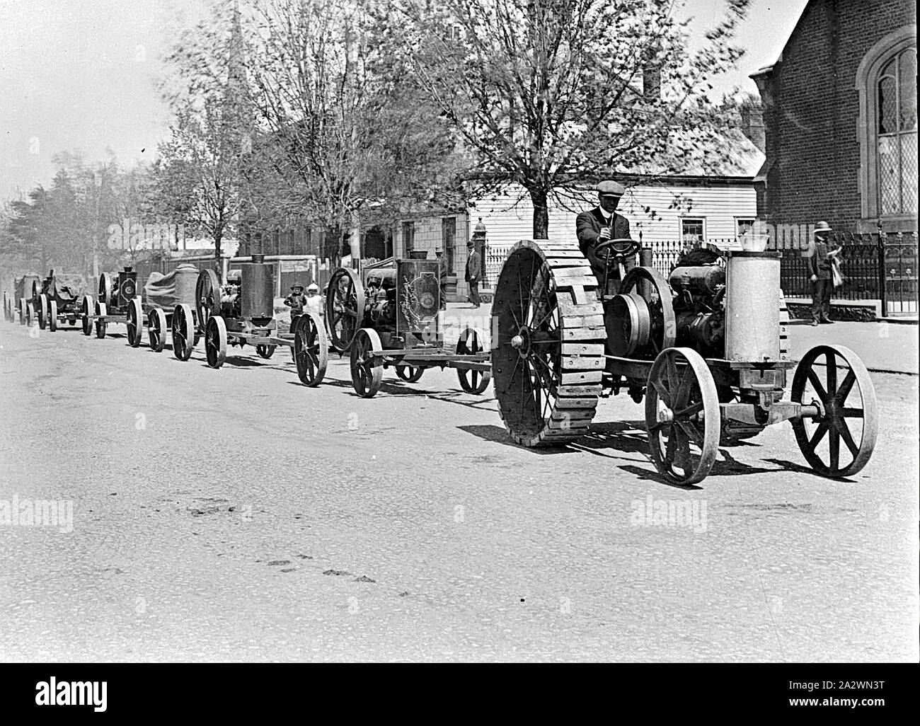 Negative - Jelbart Traktor ziehen eine Linie von Öl Motoren, Ballarat, Victoria, ca. 1915, eine Jelbart Motor Ziehen einer Linie der Öl-Motoren. Der Turm von St. Andrews Kirche in den Hintergrund und die Halle der Gemeindekirche auf der rechten Seite Stockfoto