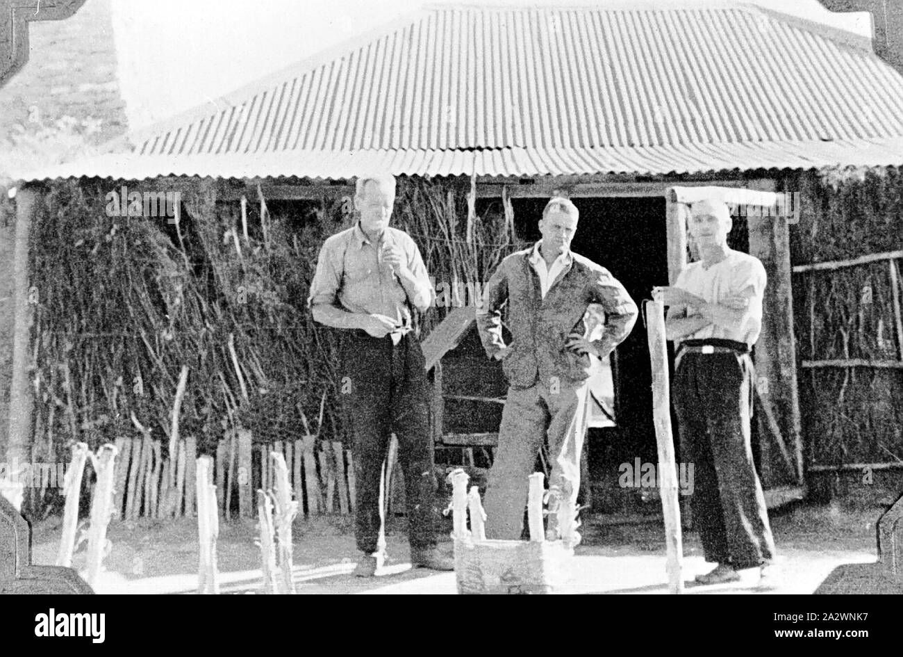 Negative - Männer am Hut, Henbury, Northern Territory, 1937, drei Männer außerhalb einer Hütte mit Wellblechdach und Pinsel Wände Stockfoto