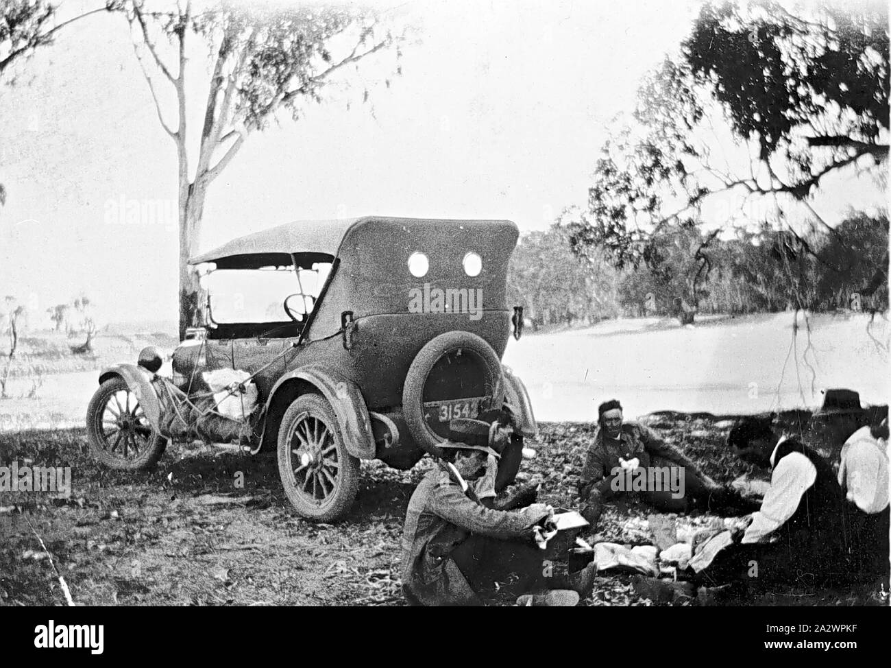 Negative - Careena Bend-Wemen, Victoria, 1921, vier Männer, darunter ein Polizist, mit dem Dodge car Die vermietet worden waren, damit sie für eine Person in den Murray River ertrunken zu suchen. Der Körper wird auf das Trittbrett des Autos gebunden. Die Männer sind Essen hinter dem Auto Stockfoto