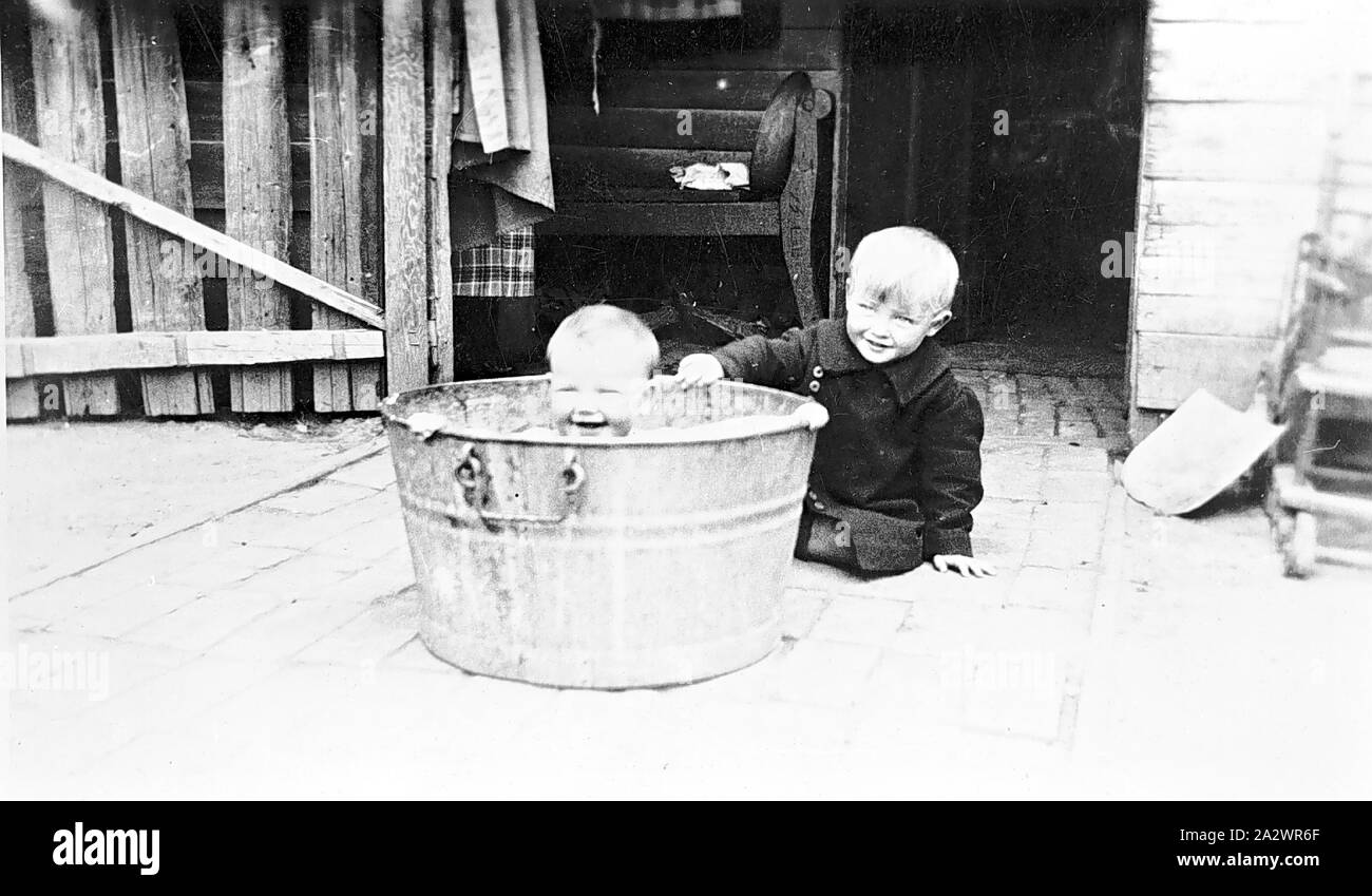 Negative - Chinkapook, Victoria, ca. 1935, ein Kleinkind in einer Badewanne, einem älteren Jungen sitzt neben der Wanne Stockfoto