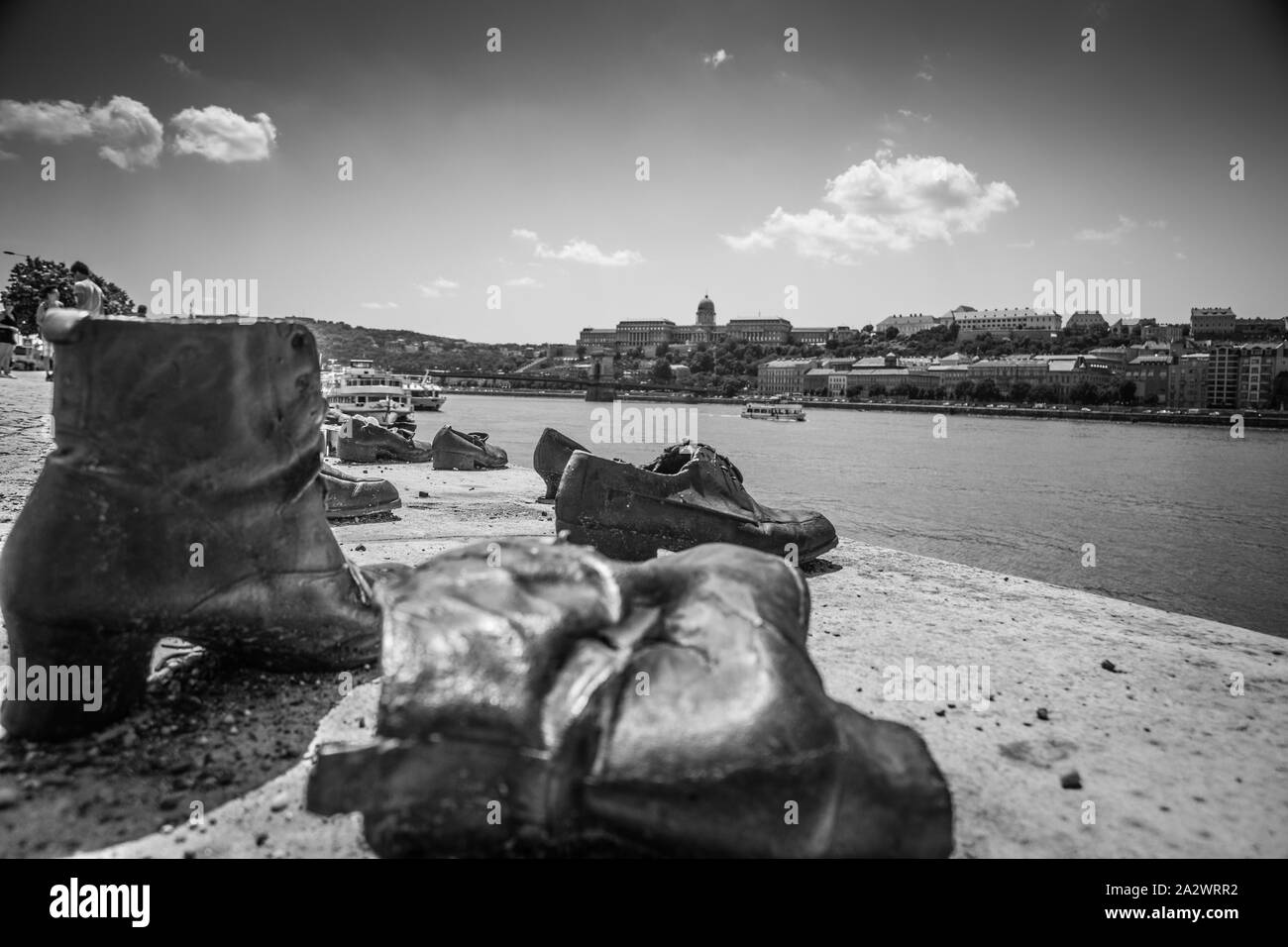 Die Schuhe am Donauufer. Denkmal - die Schuhe der Opfer des Krieges in Budapest, Ungarn. Donau und der Stadt im Hintergrund Stockfoto