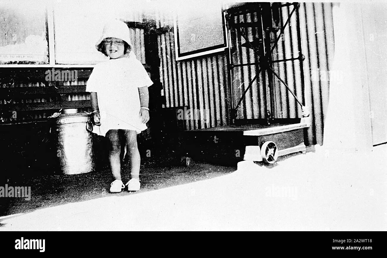 Negative - Jäger, Victoria, ca. 1935, ein kleines Mädchen mit einem Container der Creme auf der Plattform von Hunter Bahnhof. Die Creme wurde von der Schiene auf die Butter Werk geschickt zu werden. Es gibt eine Reihe von Skalen auf der rechten Seite Stockfoto