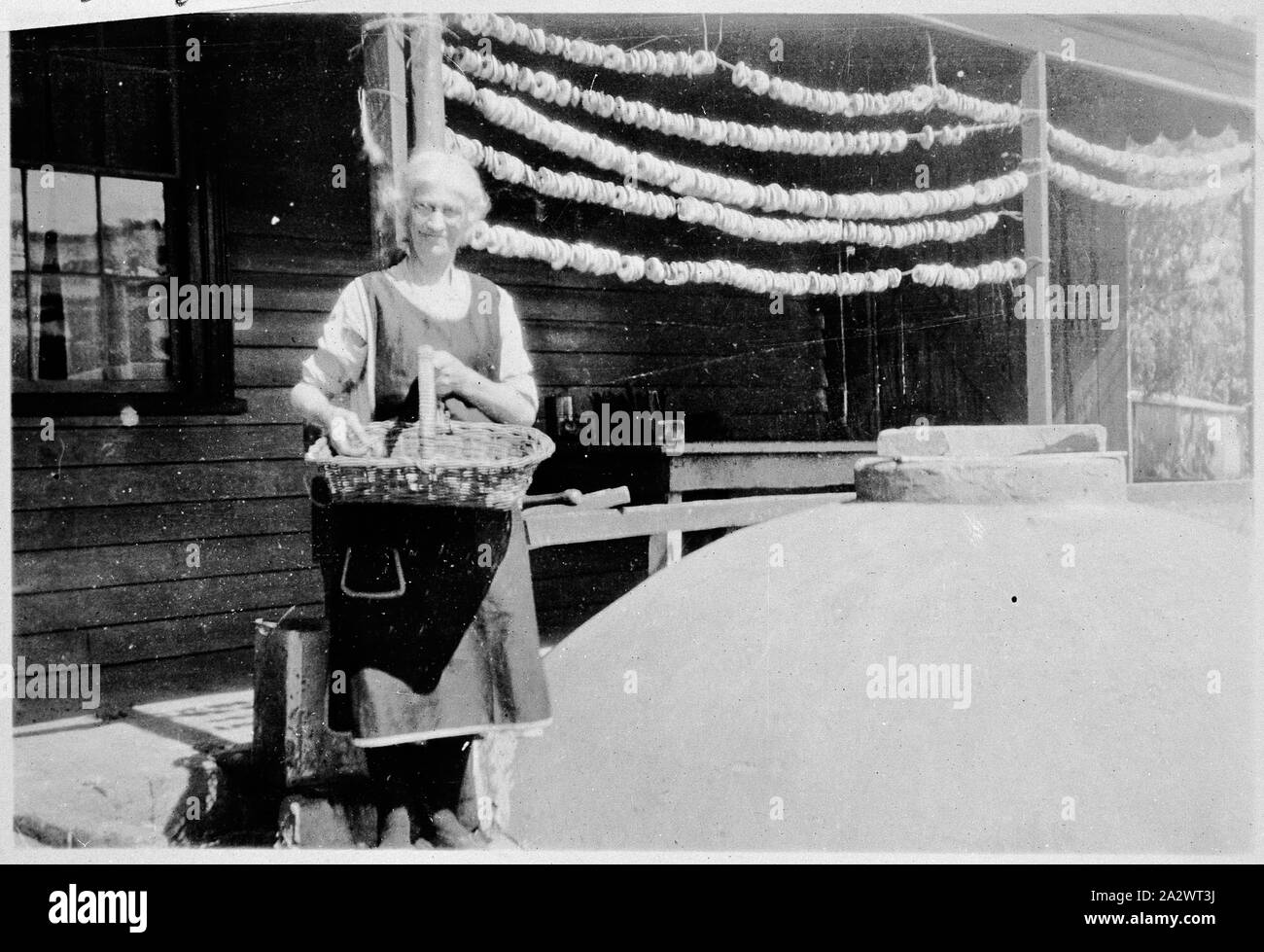 Negative - Frau Trocknen Äpfel, See Linlithgow, Victoria, ca. 1931, eine Frau, Christina Park, das Trocknen von Äpfeln. Die äpfel haben entkernt worden und werden in den Zeilen aufgereiht auf einer Veranda hing. Es ist ein gewölbter Struktur zu Ihrer Linken Stockfoto Negative - Frau Trocknen Äpfel, See Linlithgow, Victoria, ca. 1931, eine Frau, Christina Park, das Trocknen von Äpfeln. Die äpfel haben entkernt worden und werden in den Zeilen aufgereiht auf einer Veranda hing. Es ist ein gewölbter Struktur zu Ihrer Linken Stockfoto