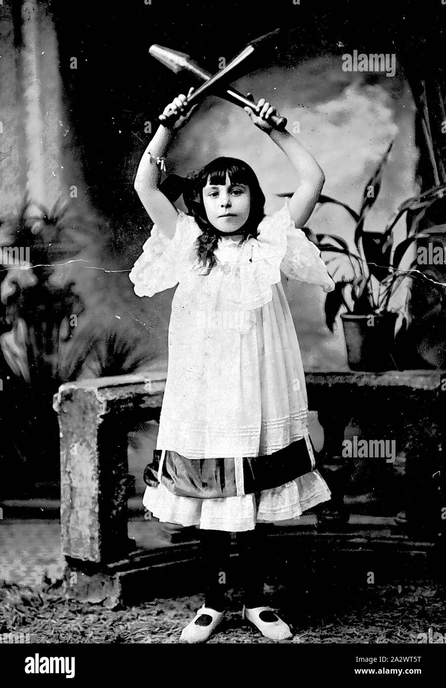 Negative - Mädchen, Calisthenics, Bendigo, Victoria, etwa um 1900, ein junges Mädchen, das für Ihre Fähigkeit im Club renommierten schwang. Sie hält die Vereine über ihren Kopf gekreuzt Stockfoto