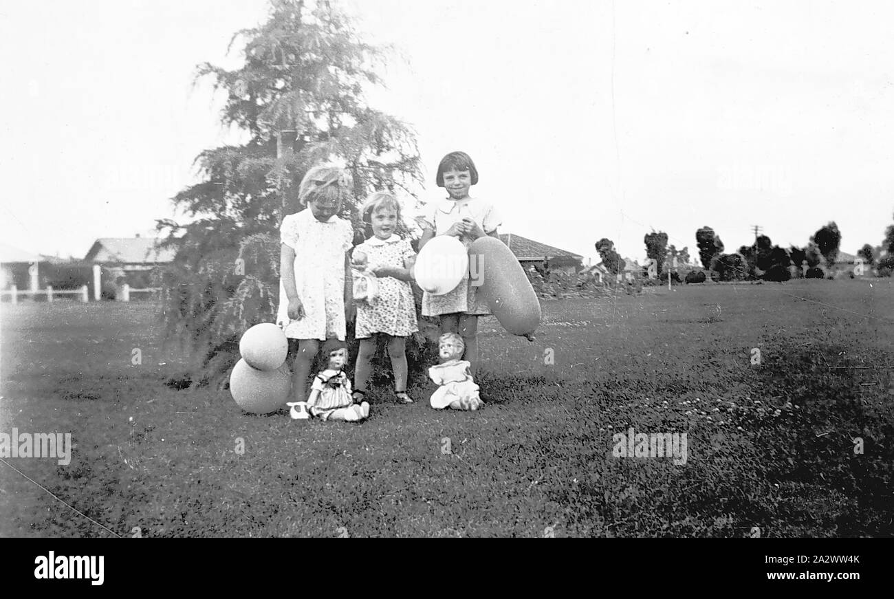 Negative - Mildura, Victoria, 1936, drei kleine Mädchen mit neuen Puppen und Luftballons erhalten für Weihnachten. Sie sind in Henderson Park Stockfoto