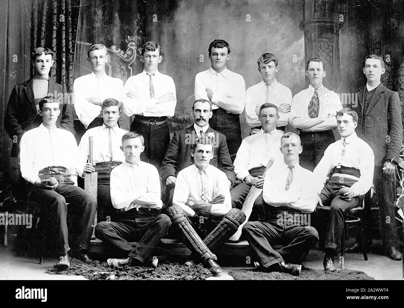 Negative - Footscray, Victoria, um 1910, Mitglieder der Gordon Parade Cricket Club. Die wicketwächter sitzt im Schneidersitz in den vorderen Querträger Stockfoto