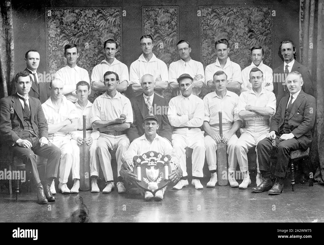 Negative - Newport, Victoria, circa 1925, die Newport Workshops Cricket Team. Die wicketwächter sitzt vor einer Meisterschaft Schild Stockfoto
