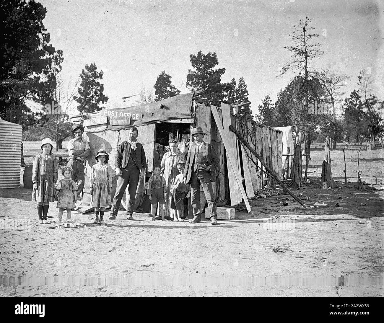 Negative - Goulburn Valley (?), Victoria, ca. 1915, eine Gruppe außerhalb eine Hütte gebaut der hessischen und Wellblech. Die Hütte führt ein Zeichen, mit dem sie als Datei identifiziert eine Post Stockfoto