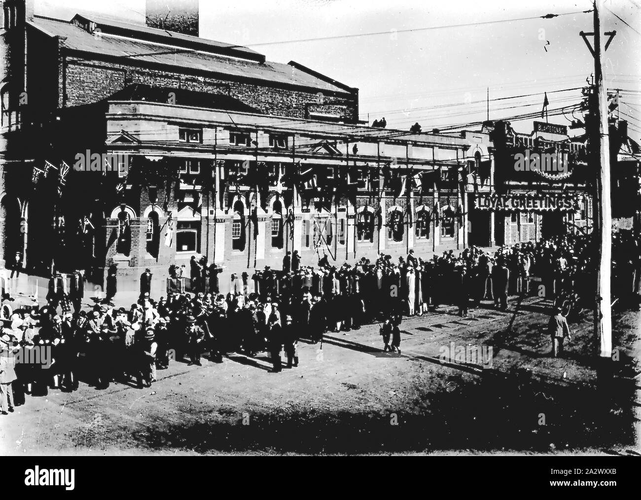 Negative - Geelong, Victoria, ca. 1928, eine Masse für einen königlichen Besuch gesammelt. Blakistan & Unternehmen ist im Hintergrund der Masse eine Parade route gefüttert haben. Fahnen und Banner schmücken die Route Stockfoto