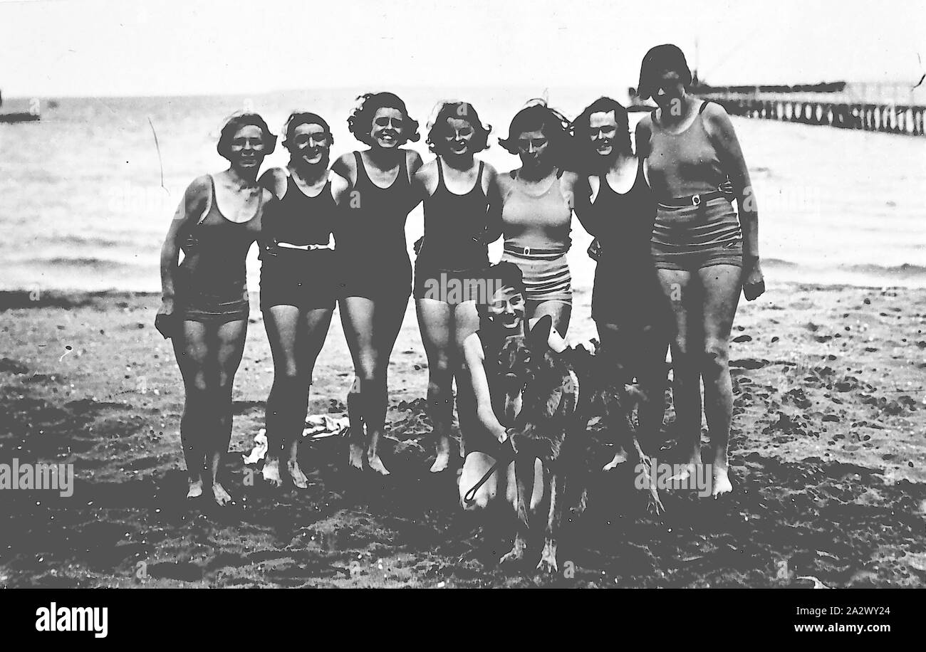 Negative - Geelong (?), Victoria (?), ca. 1930, eine Gruppe von jungen Frauen in Badekleidung am Strand. Es ist ein Pier im Hintergrund Stockfoto