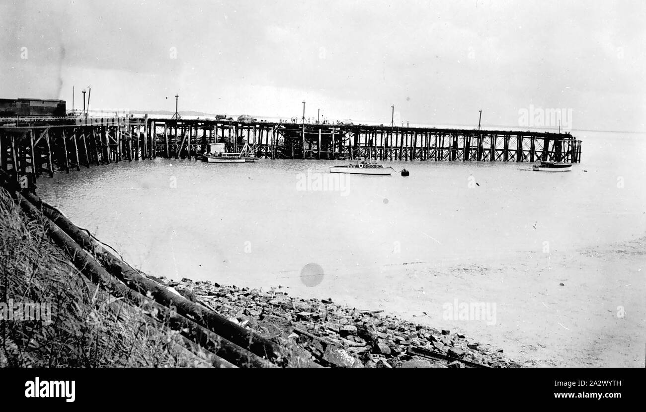 Negative - Darwin, Northern Territory, 1948, Stokes Hill Wharf, Darwin, bei Ebbe. Der Schiffsrumpf des MV Neptuna sichtbar ist durch das Wharf Masten auf der linken Seite unterhalb des Autos und Menschen auf der Wharf ist ein britisches U-Boot, der Besuch war Darwin auf dem Weg nach Hongkong Stockfoto