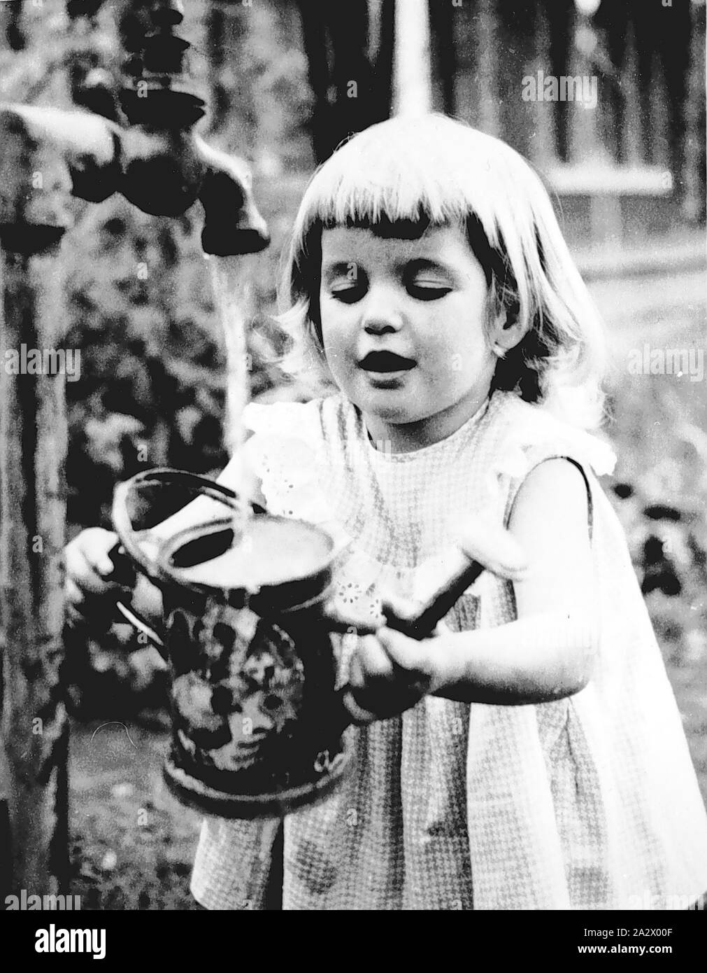 Negative - Kew, Victoria, ca. 1955, ein Kind eine kleine Gießkanne aus einem Hahn Stockfoto