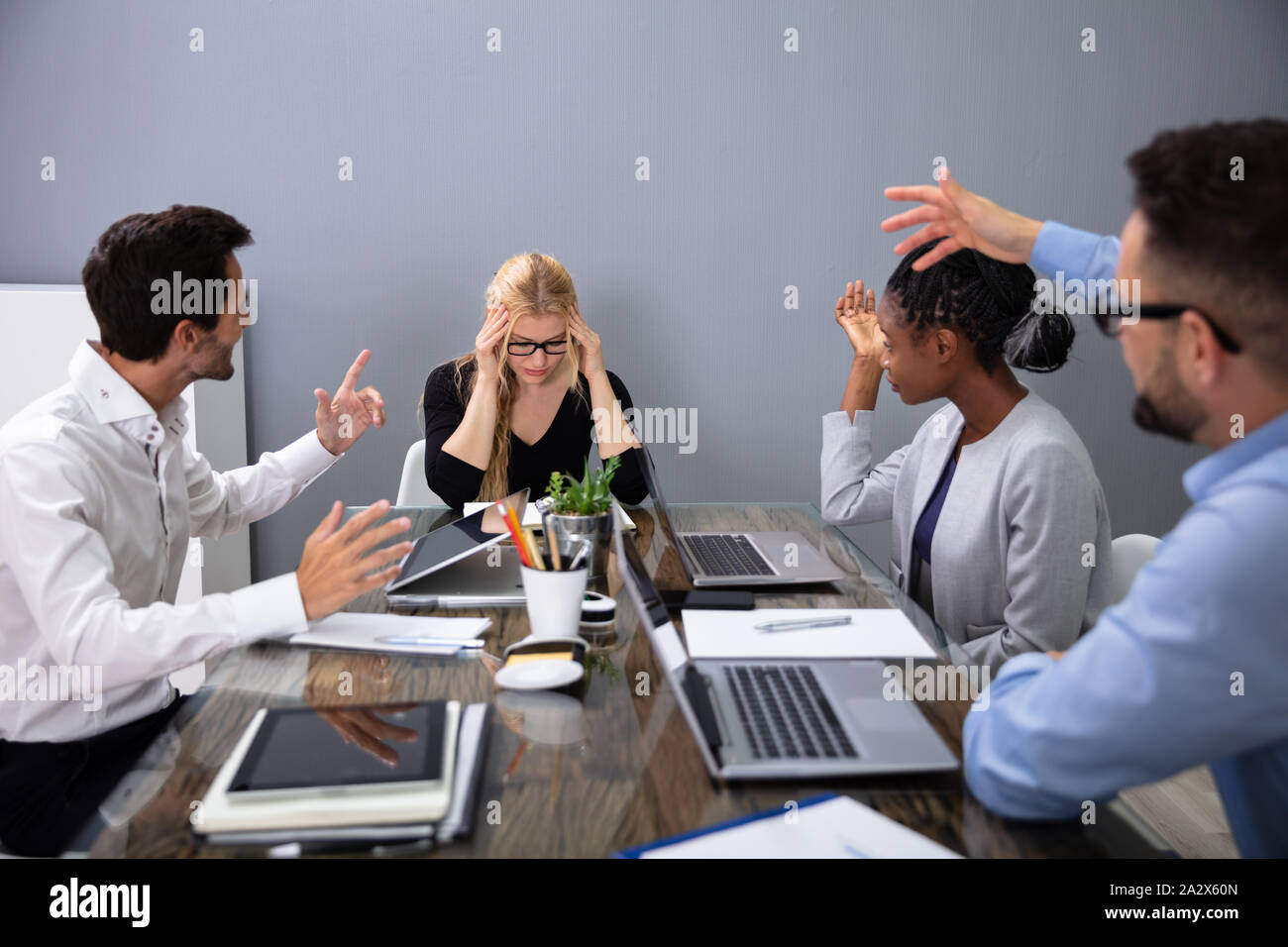 Geschäftsfrau, Sitzen mit Jungen aggressiven Kollegen in Sitzung Verärgert Stockfoto