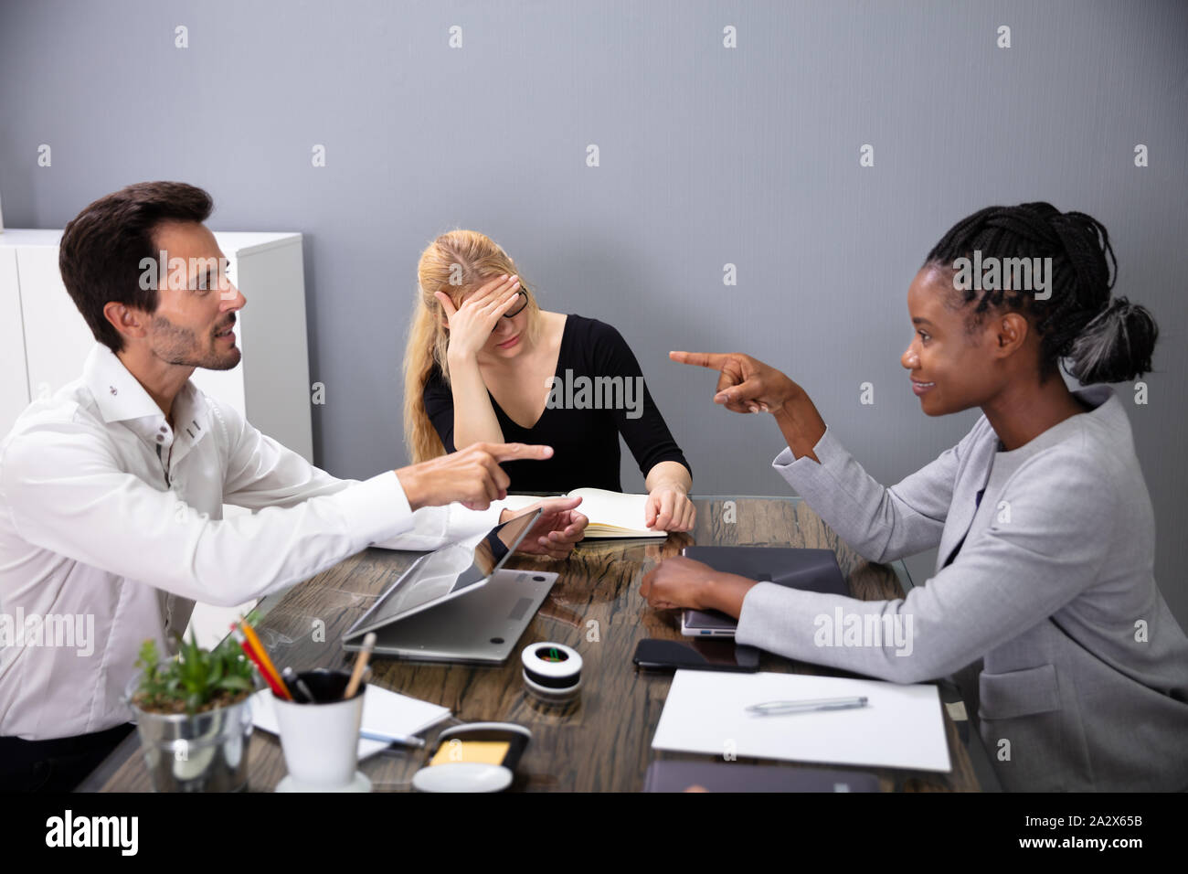 Geschäftsleute, die sich gegenseitig die Schuld beim Besprechen mit Ihren Kollegen in der Konferenz Stockfoto