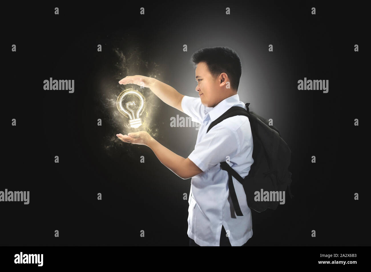 Glückliche junge männliche Schüler in der Schule Uniform mit Rucksack und sah eine Idee. Glühlampe Idee Konzept. Erfolg, kreativ, und Idee Konzept. Stockfoto