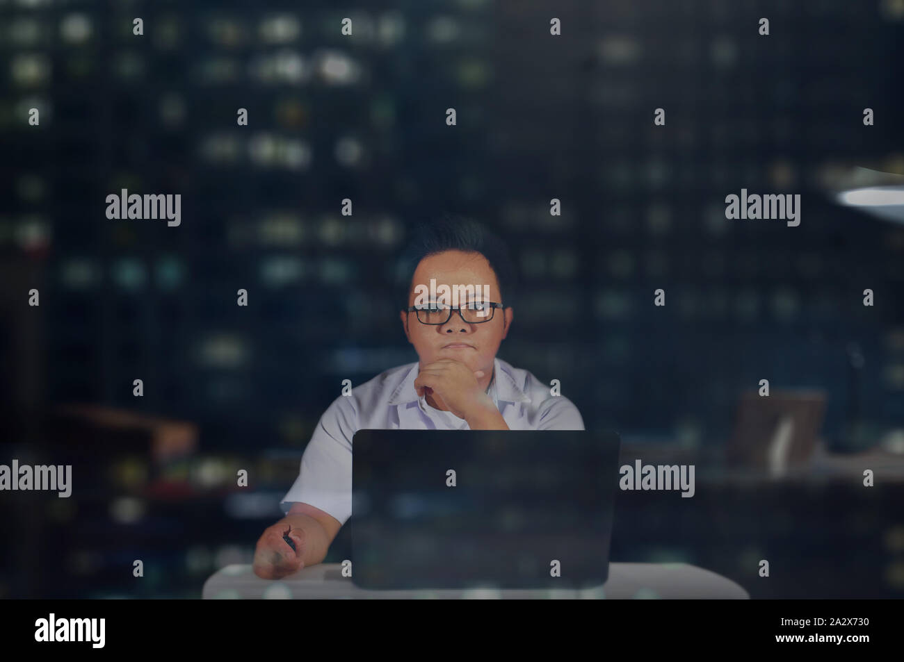 Ernsthafte Kerl. Und denken sehr konzentrieren. Mann im Büro vor seinem Laptop in der Nachtschicht arbeiten. Ein Büro Job eine Nacht. Stockfoto