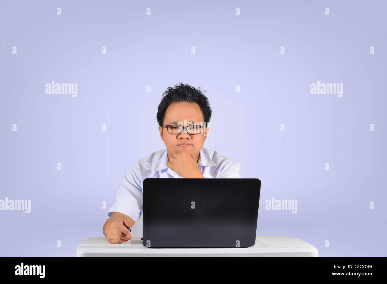 Eine ernsthafte Suche Schüler denken. Junge männliche Kursteilnehmer in die Kamera schaut. Studio shot in Weiß isoliert Hintergrund. Sehr konzentrierte Geschäftsmann. Stockfoto