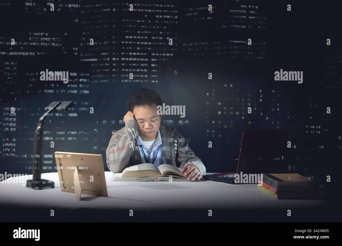 Büro Zimmer schossen hinter dem Glas. Schule junge studieren um Mitternacht und cramming die Nacht vor der Prüfung. Schüler in der Schule uniform einzuschlafen. Stockfoto