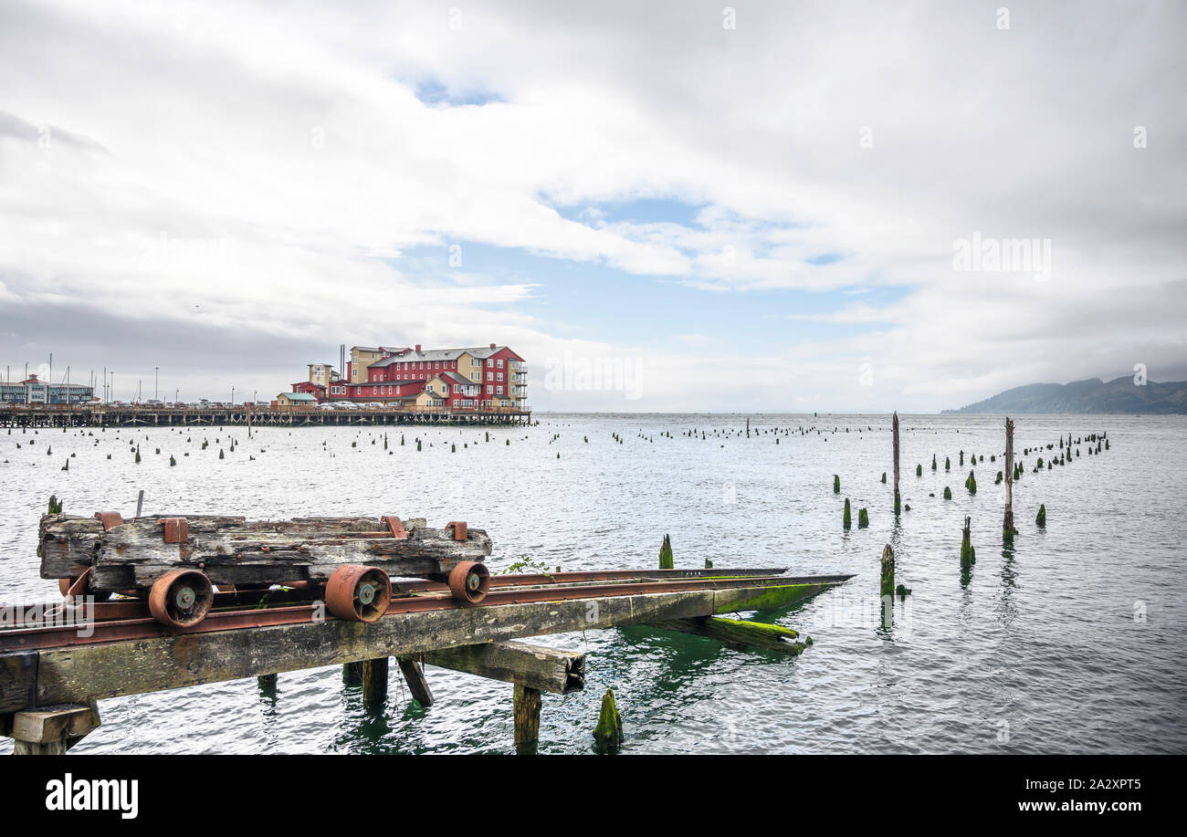 Eine alte rostige Trolley für das Be- und Entladen von Luftfracht steht auf den Schienen auf Stelzen ins Wasser des Pazifischen Ozeans in Astoria in der Nähe der Bri Stockfoto