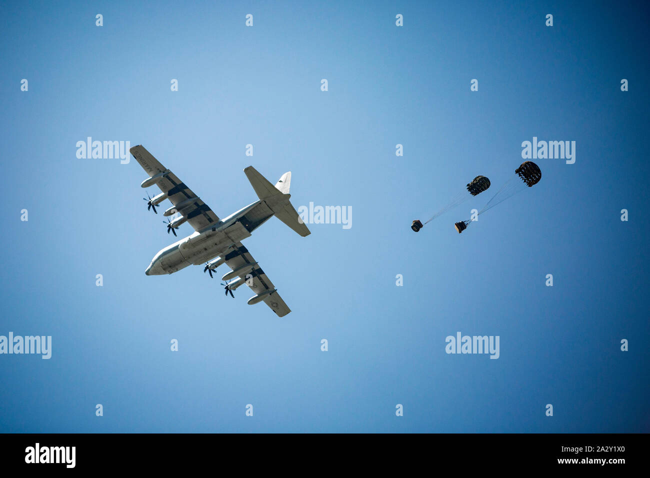 Eine C-130 Flugzeugen fällt genau Cargo während einer Übung auf der Insel Ie Shima, Okinawa, Japan, Oktober 2, 2019. Die Ausübung betonte, sichere und effektive Bereitstellung von Personal und Ausrüstung. (U.s. Marine Corps Foto von Cpl. Christopher Madero) Stockfoto
