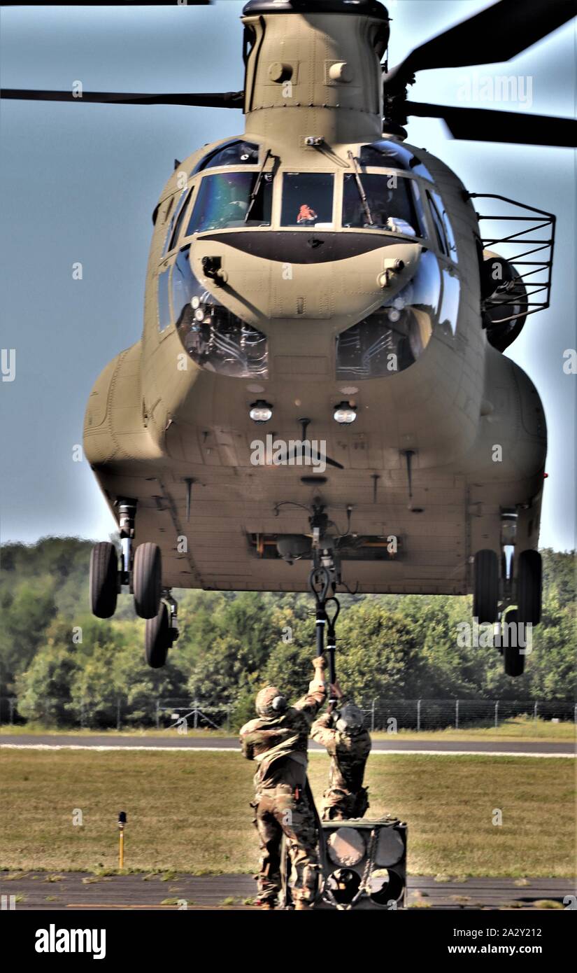 Schüler der 89 B Munition liefern Kurs verbinden ein mock Munition Palette zu einem CH-47 Chinook Hubschrauber Aug 1, 2019, als Teil der Schlinge - last Ausbildung bei Sparta-Fort McCoy Flughafen am Fort McCoy, Wis die Chinook und die Crew sind ab dem 7. Bataillon, 158 Aviation Regiment des neuen Jahrhunderts, Kansas. Die Munition liefern, von der 13 Bataillon gelehrt, 100 Regiment am Fort McCoy, ist einen 4-wöchigen Kurs, der eine Schulung für die Soldaten, die Umgliederung der 89 B militärische berufliche Spezialität sind. Die Schlinge - last Training ist einer der letzten großen Ausbildung Veranstaltungen während des Kurses. Ein s Stockfoto
