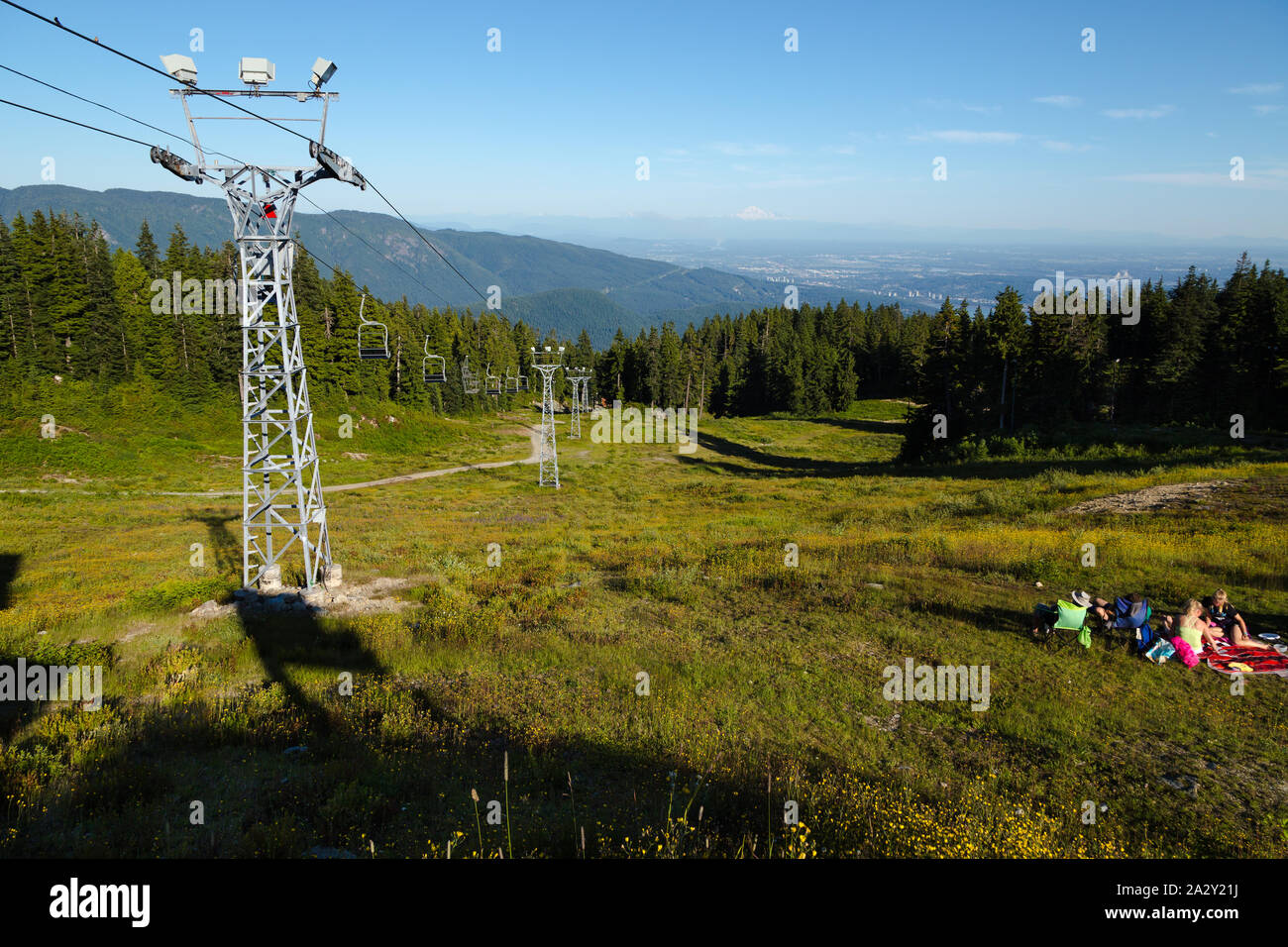 Der Skilift neben der Skipiste Wanderweg an der Spitze von Seymour Berg in North Vancouver, BC, mit Blick auf den Fraser Valley und Mt. Baker in Stockfoto