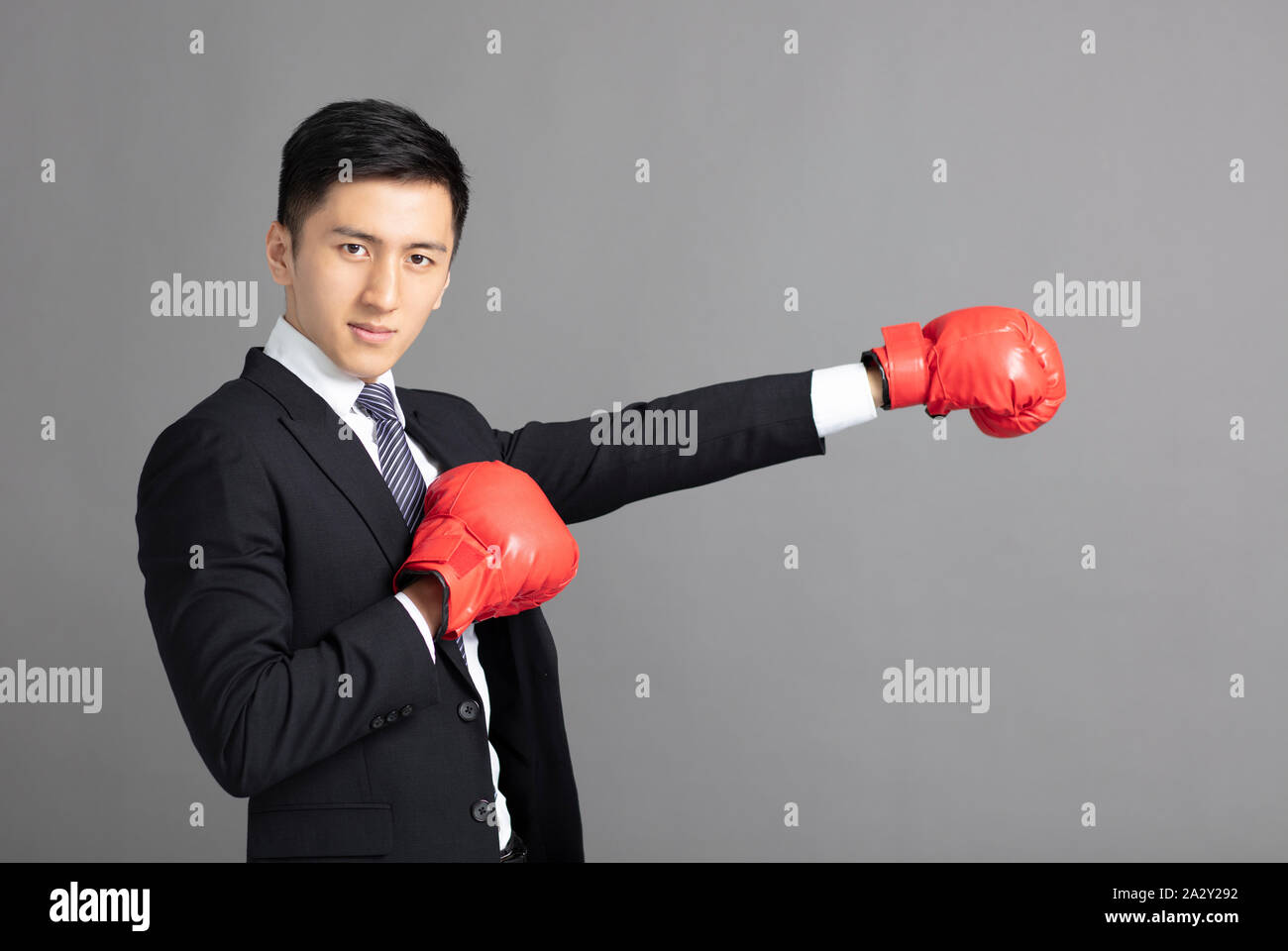 Junge Geschäftsmann bereit, mit Boxhandschuhen zu kämpfen Stockfoto