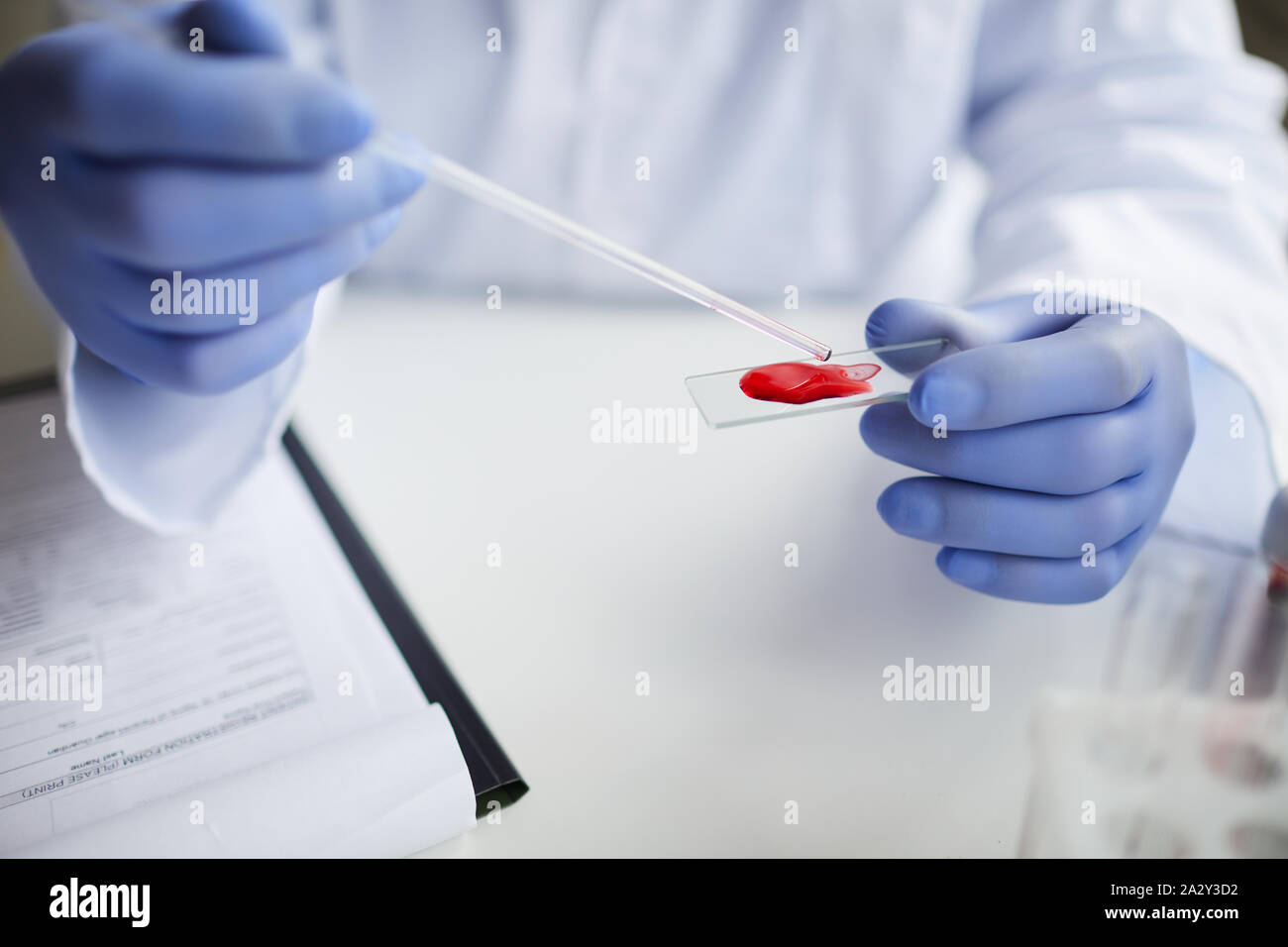 In der Nähe von Doktor in Schutzhandschuhe holding Glas mit Blutprobe und prüft es im Labor Stockfoto