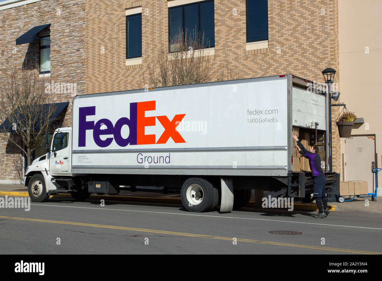 Ein FedEx-Lieferfahrer entlädt am Donnerstag, 14. März 2019, einen LKW im Bridgeport Shopping Center in Tigard, Oregon. Stockfoto