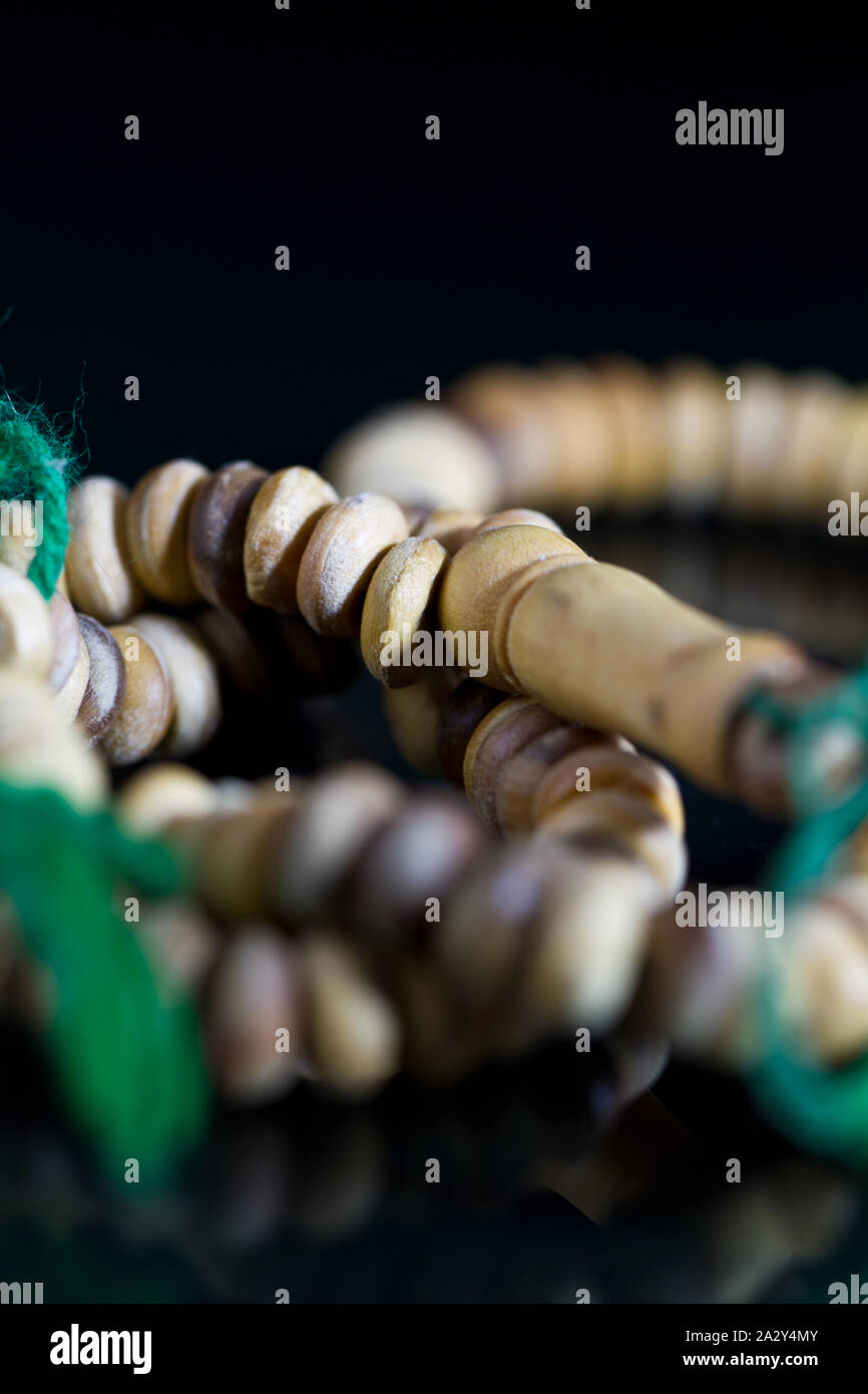 Eine hölzerne beten Perlen oder tasbih oder Rosenkranz mit grünen String mit dunklen Hintergrund Stockfoto