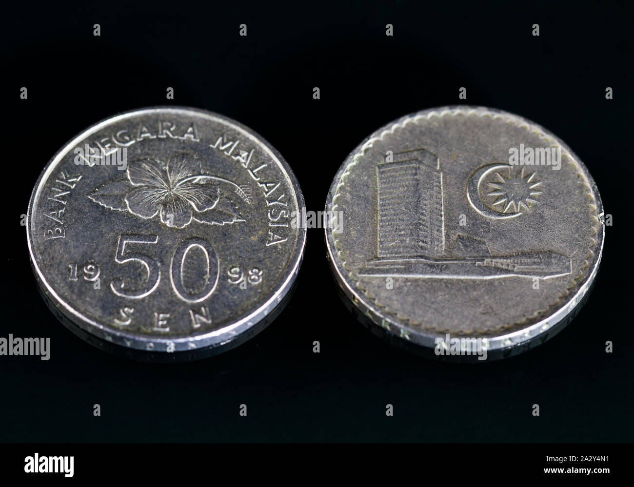 Malaysische Währung Münzen in verschiedenen Stückelungen auf einem schwarzen Spiegelfläche Stockfoto