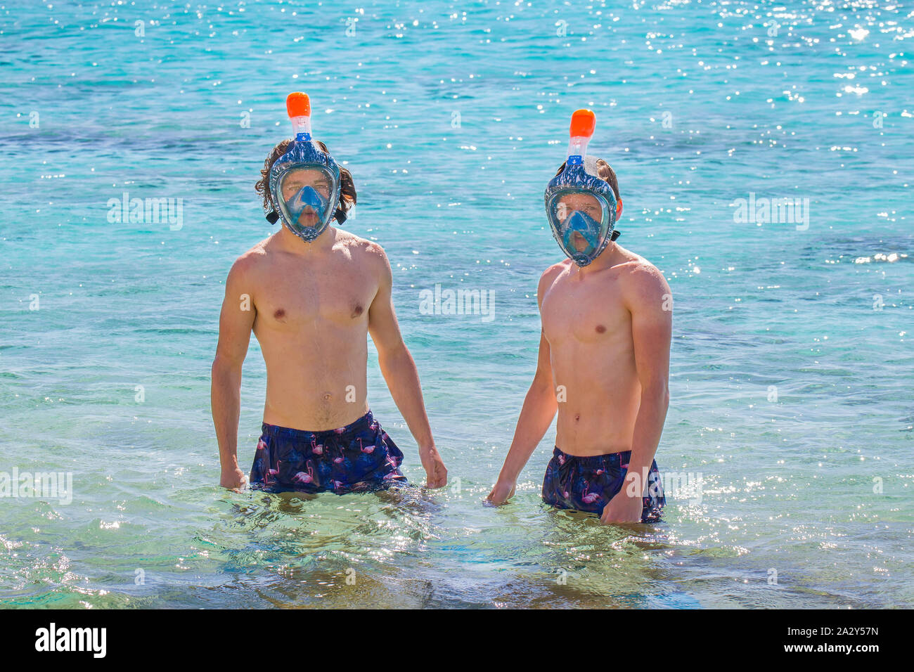 Zwei jungen kaukasischen Männern das Tragen von Masken im Meer schnorcheln Stockfoto