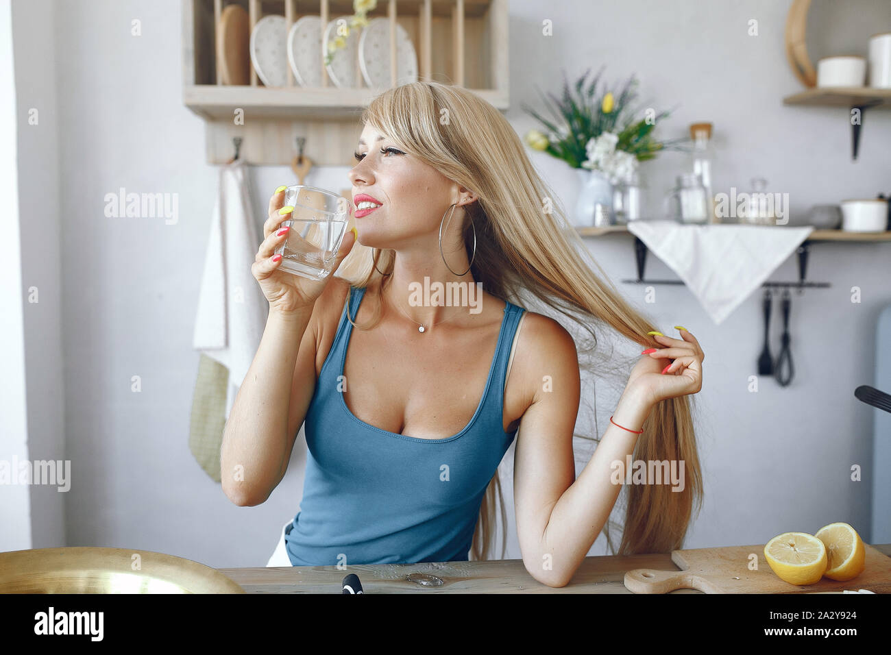 Schöne Mädchen machen einen Salat. Sportliche Blondine in einer Küche Stockfoto