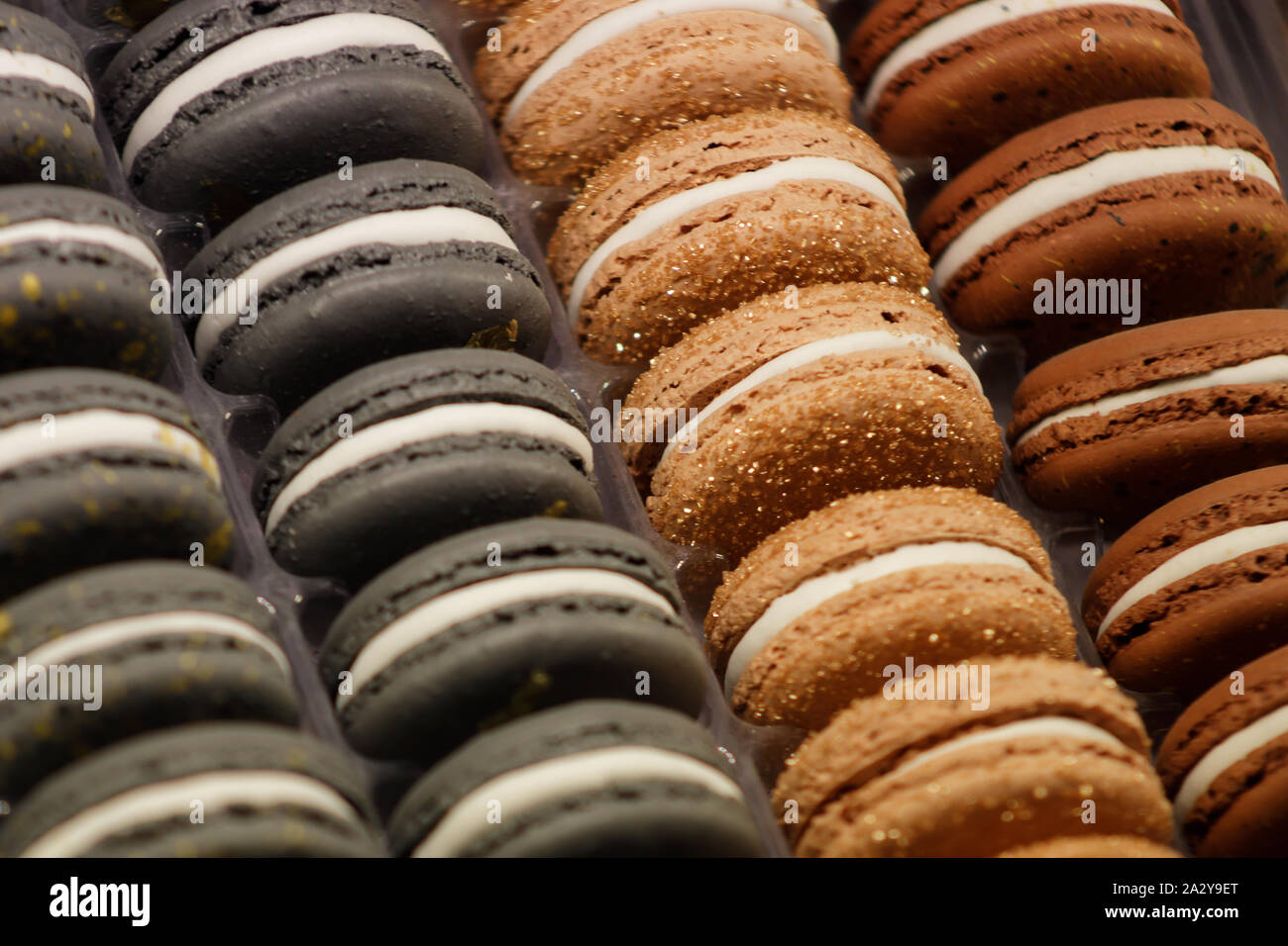 Mandel kuchen Macaron mit einer viskosen Mitte und knusprigen Shell ist einer der elegantesten Kuchen des modernen Frankreich. Bunte macarons liegen in Zeilen. Stockfoto