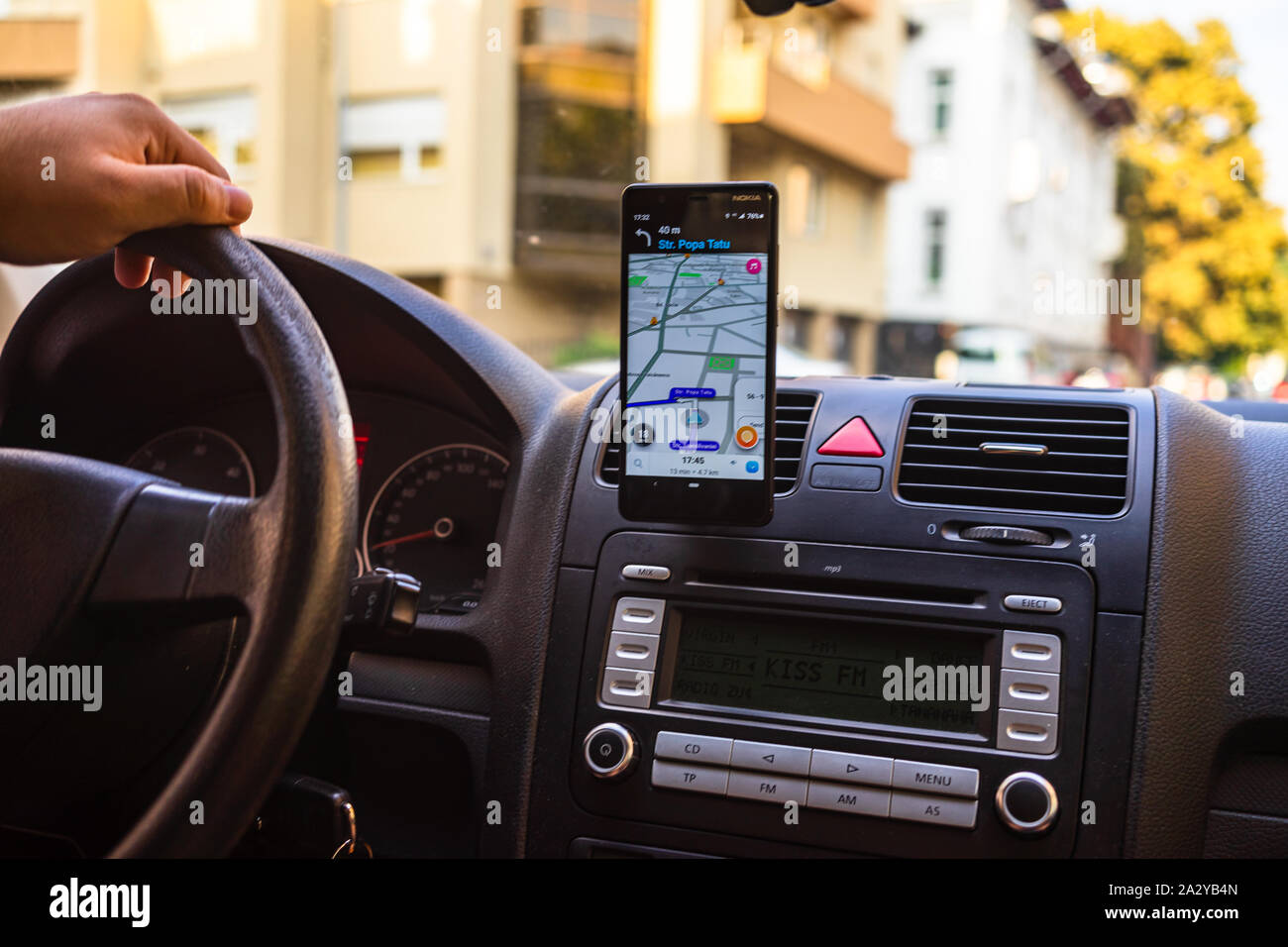 In dem Auto Dashboard-ansicht mit Smartphone angezeigt Waze Karten weisen den Weg durch die Stadt in Bukarest, Rumänien, 2019 Stockfoto