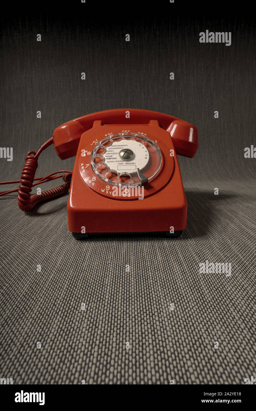 Altmodisches rotes Telefon 1960er Jahre in stimmungsvoller, finsterer Atmosphäre. Stockfoto