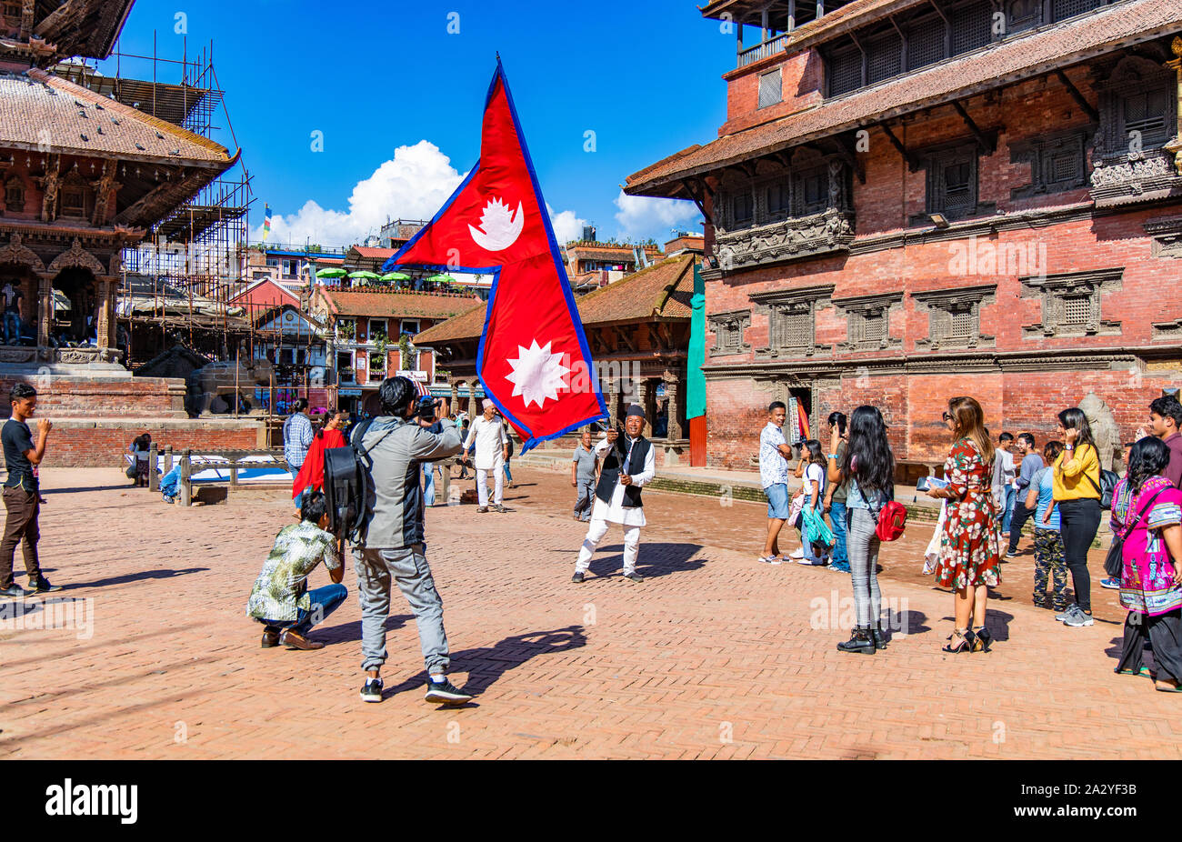 Junger Mann mit National Flagge Nepal über einen hellen Tag in Patan Durbar Square. Stockfoto