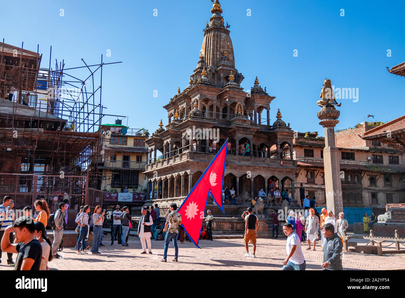Junger Mann mit National Flagge Nepal über einen hellen Tag in Patan Durbar Square. Stockfoto
