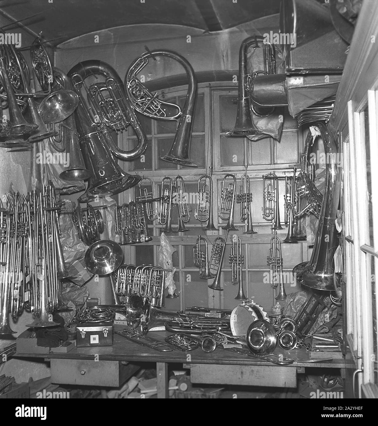 Die Arbeiter in den 1940er Jahren. Innenraum eines mechanischen Werkstatt für Musikinstrumente. Messing Musikinstrumente in verschiedenen Formen und Größen gesehen werden, die an den Wänden. Schweden 1941 Kristoffersson Ref. 225-7 Stockfoto
