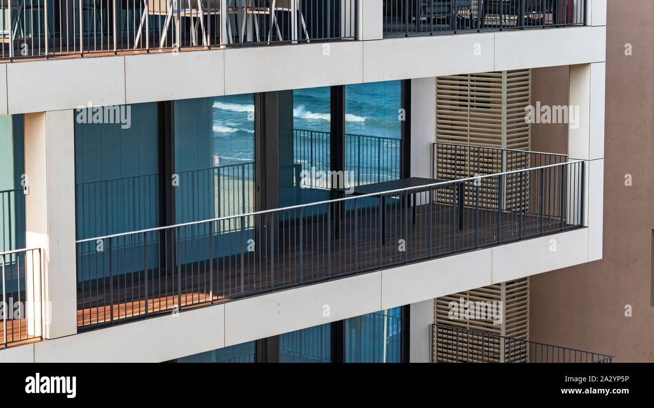 Das Mittelmeer surfen Sie auf Tel Aviv Beach befindet sich im verglasten Balkon Türen eines Hotel Apartment Gebäude durch Eisen Geländer gerahmte relected Stockfoto