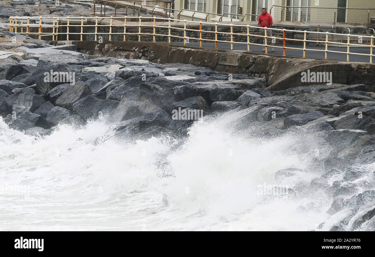 Ein Mann wacht die Wellen am Meer entlang in Lahinch, County Clare, an der Westküste von Irland, in der sich Tausende von Haushalten und Unternehmen ohne Strom geblieben sind als Sturm Lorenzo in ganz Irland. Stockfoto