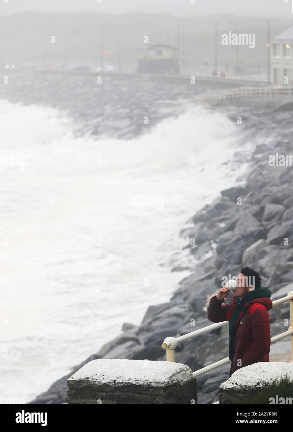 Ganaa Devee, ein Surfer aus der Mongolei, Uhren die Wellen am Meer entlang in Lahinch, County Clare, an der Westküste von Irland, in der sich Tausende von Haushalten und Unternehmen ohne Strom geblieben sind als Sturm Lorenzo in ganz Irland. Stockfoto